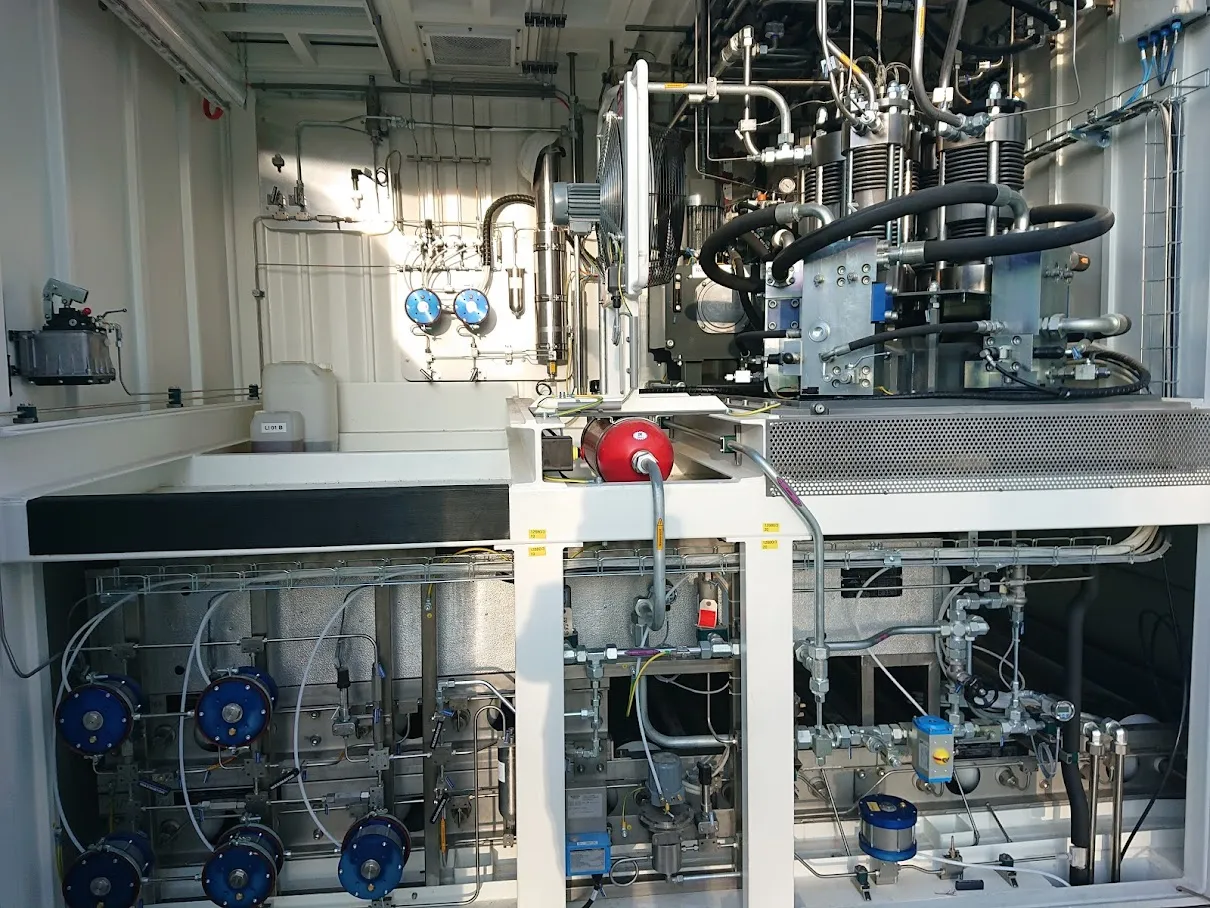 Container interior with a five-cylinder ionic hydrogen compressor above the gas panel