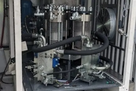 Open compressor enclosure showing two finned compression cylinders and the hydraulic drive block